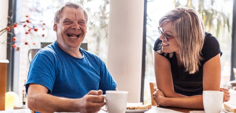 Disabled-man-eating-breakfast-with-sibling-scaled-e1627536260910-780x376
